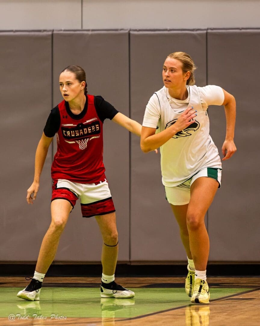 Two female basketball players competing intensely on the court.