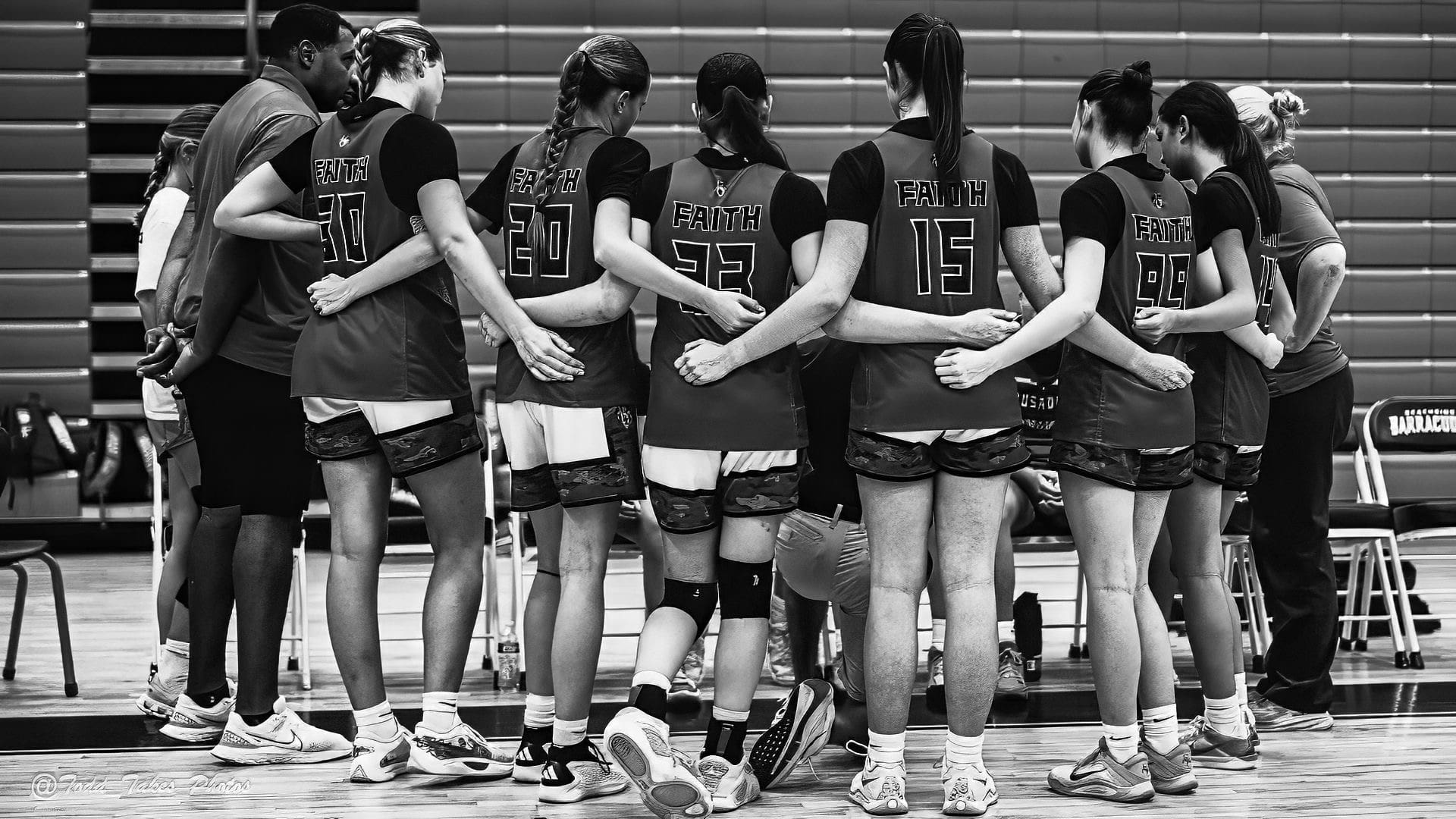 Female volleyball team huddling together before a game.