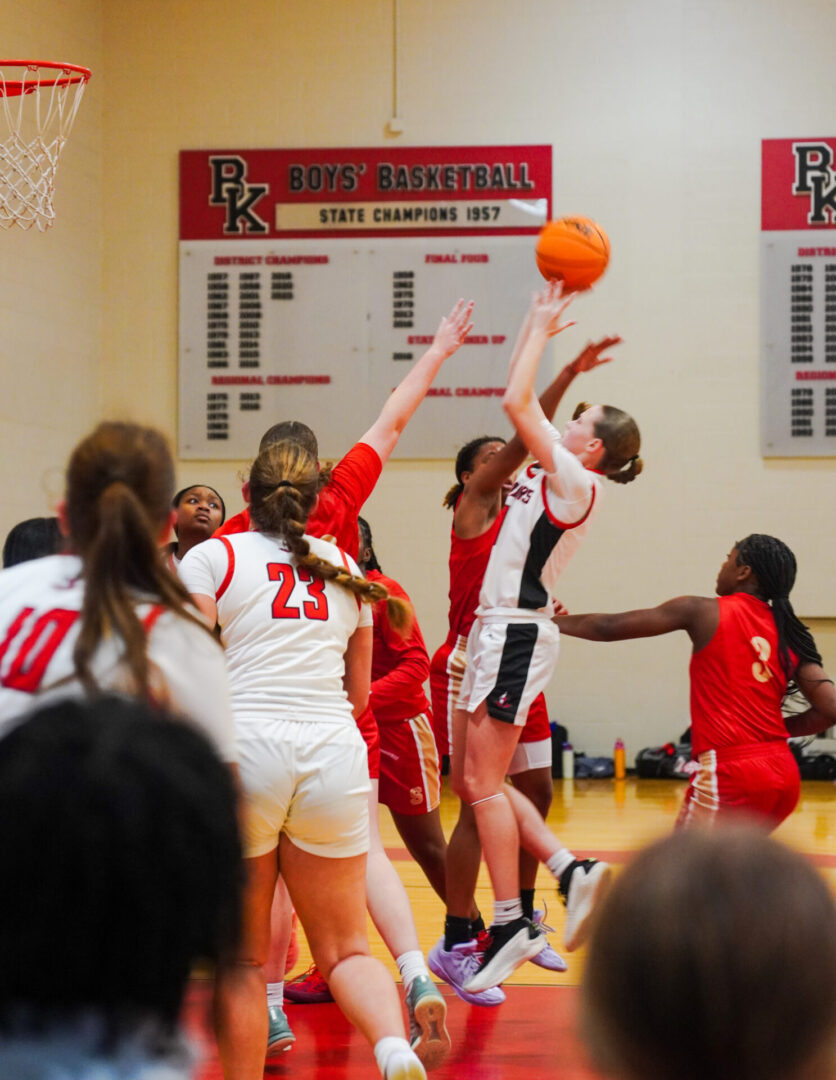 High school girls basketball game with a player shooting the ball.
